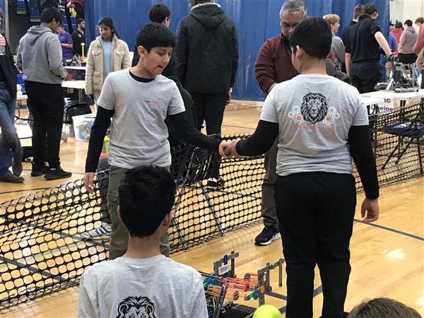 Students wearing the LMS Robotics Club shirt are at a VEX IQ competition.